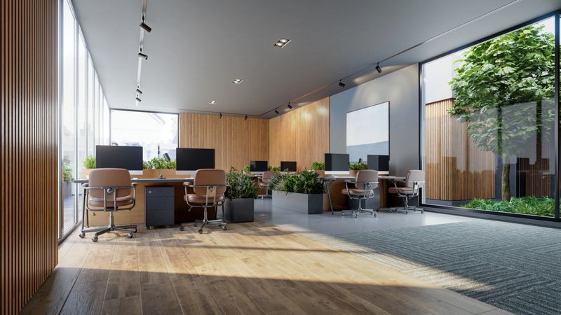 Spacious corporate workspace features vertical wood slat walls, floor-to-ceiling glass windows, and sleek track lighting. Hardwood flooring transitions into grey carpeting to define distinct work zones.