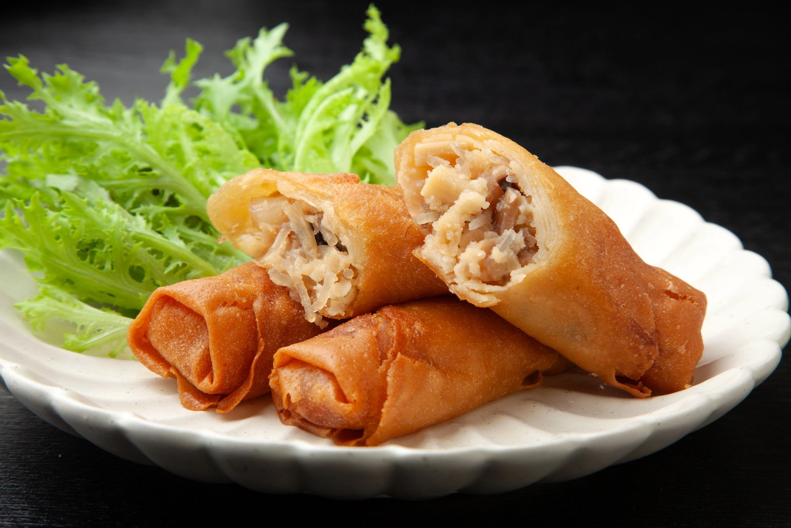 Crispy fried spring rolls with green lettuce.