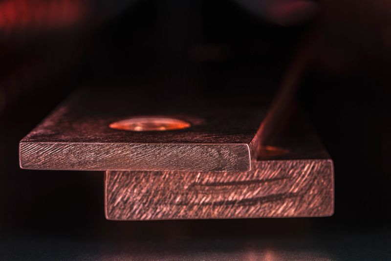 Grounding busbar in electrical power installations, a close-up of copper structure in an industrial dark environment