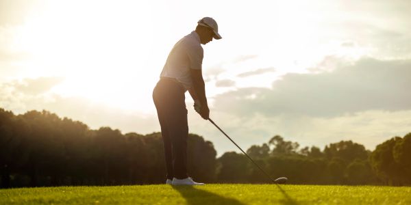 Golfer preparing to swing on a sunny course.