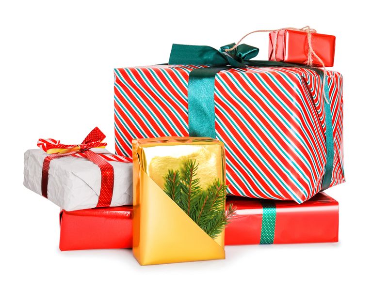 Stack of colorful Christmas presents wrapped in festive paper and ribbons, isolated on a white background. High quality photo