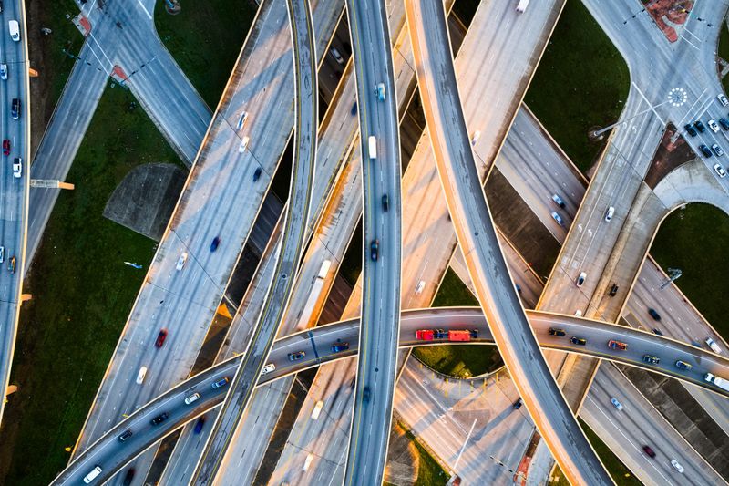 Aerial Photo of the High Five Interchange in Dallas, Texas, featuring the multi-level junction of US-75 (Central Expressway) and I-635 (Lyndon B. Johnson Freeway), with flowing traffic and expansive urban infrastructure.