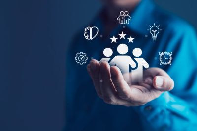 Hand holding icons representing creativity and teamwork.