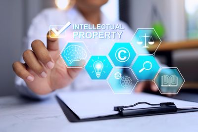 Person interacting with digital icons representing intellectual property concepts.