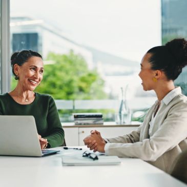 Two women having a friendly meeting in an office.