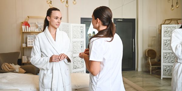 Two women conversing in a spa setting.