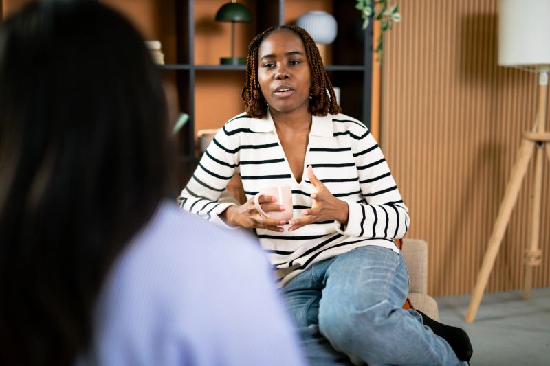 Young black woman talking to counselor, discussing mental health issues