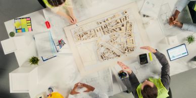 People collaborating on architectural plans and models.