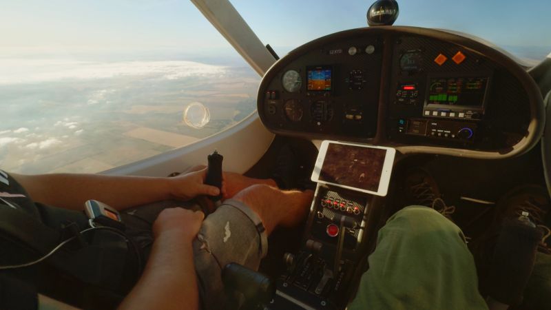 Point of view shot of experienced pilot holding the control stick, steering small aircraft with single engine. Morning flight at sunrise with a friend. Luxury hobbies and high society