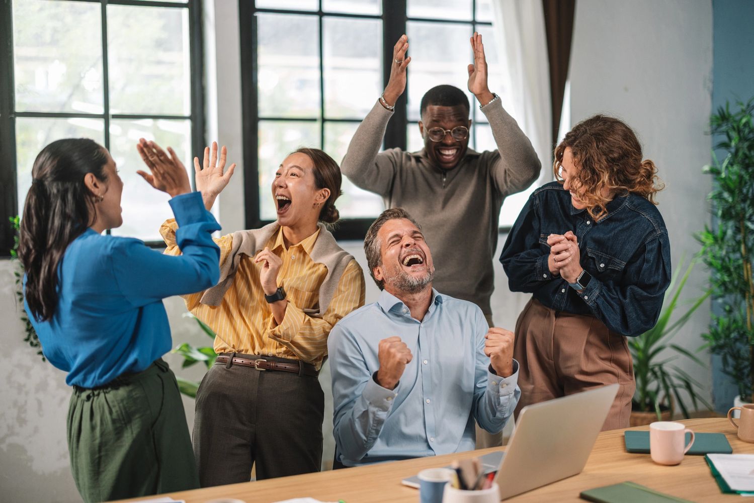 Stack of books next to pencils in a holder and a camera.