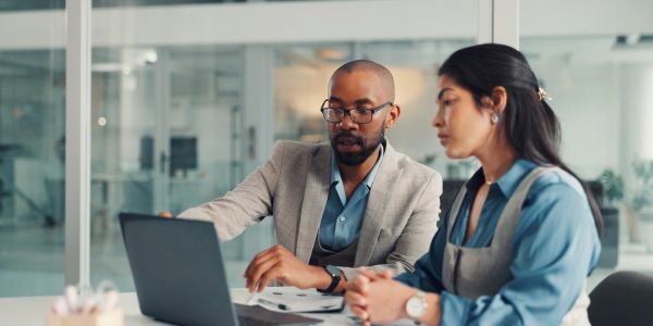 Two coworkers discussing work in an office.