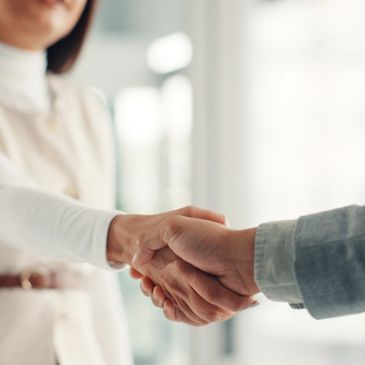 Two people shaking hands in a professional setting.