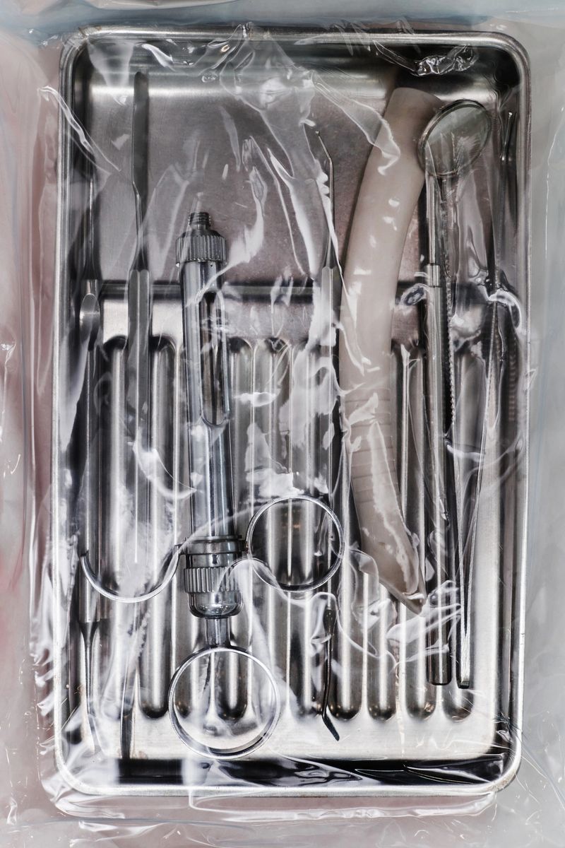Sterile dental instruments set including dental mirror, explorer, forceps, scaler, air water syringe, suction tube sealed in plastic packaging prepared for patient treatment in dental office