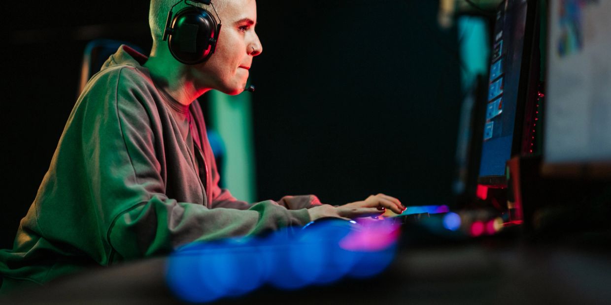 Person focused on computer gaming with headset on.