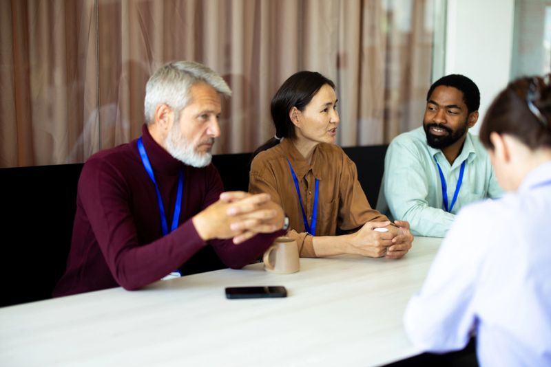 Multi-ethnic hr managers interviewing woman for job position in modern office