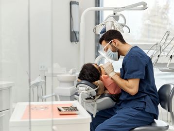 Dentist treating patient in clinic.