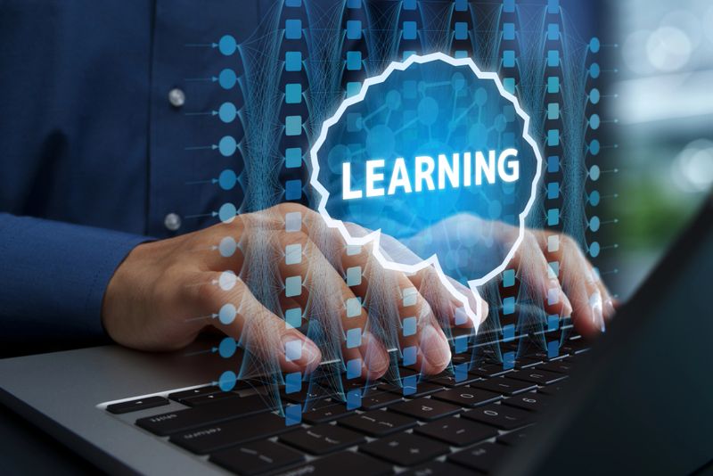 Businessperson using laptop computer with adaptive AI assistant and intelligent automation.