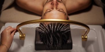 Man getting hair washed in a salon sink.
