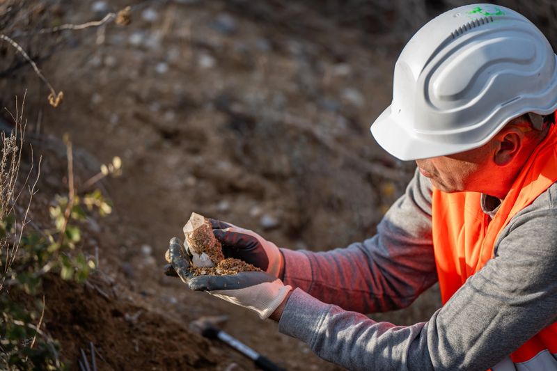 Geologist searching for and examining minerals in an open-air quarry. Tools, hammer... a precious piece of mineral. Geology in winter. Tordesillas, Valladolid, Castile and León, Spain, Europe - November 12, 2025.