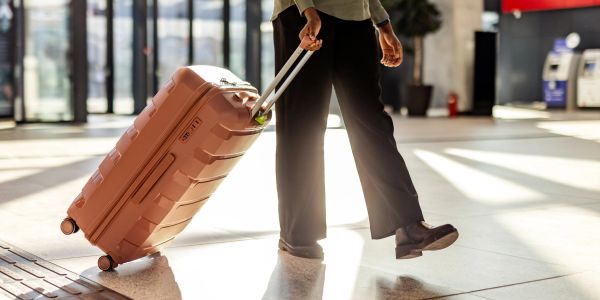 Person walking with a suitcase in an airport.