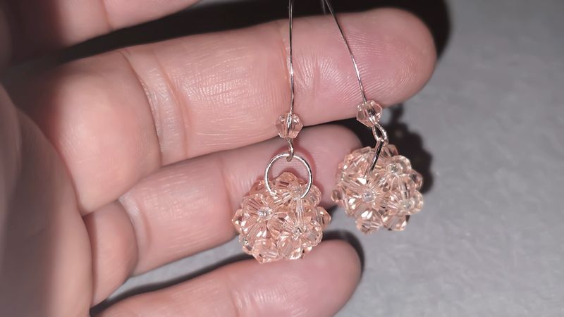 Handmade beaded and glass bead earrings on a light background. Silver and gold hardware. Stylish and fashionable accessories. Copy space.