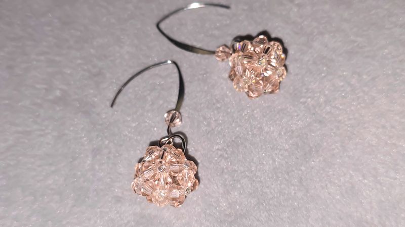 Handmade beaded and glass bead earrings on a light background. Silver and gold hardware. Stylish and fashionable accessories. Copy space.