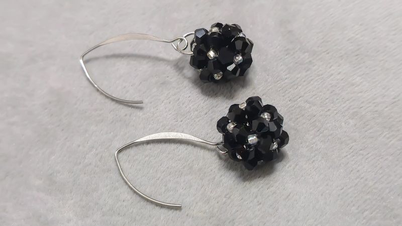 Handmade beaded and glass bead earrings on a light background. Silver and gold hardware. Stylish and fashionable accessories. Copy space.