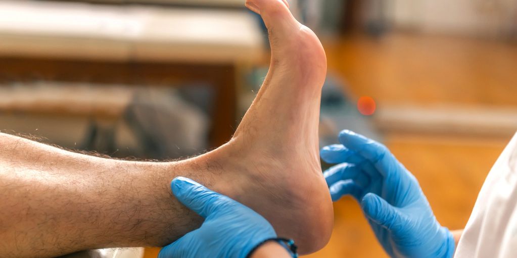 Évaluation du pied par un podologue gants bleus.