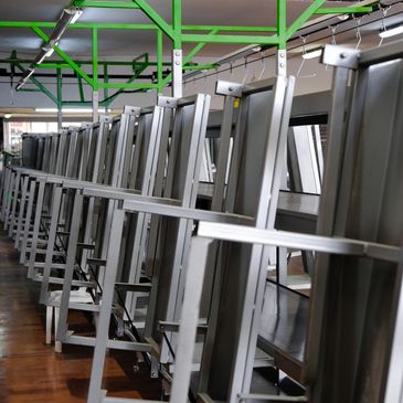 Row of metallic treadmills in a gym with green ceiling beams.
