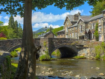 Stone bridge over a flowing river in a quaint village.