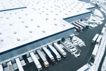 Snow-covered loading dock with trucks.