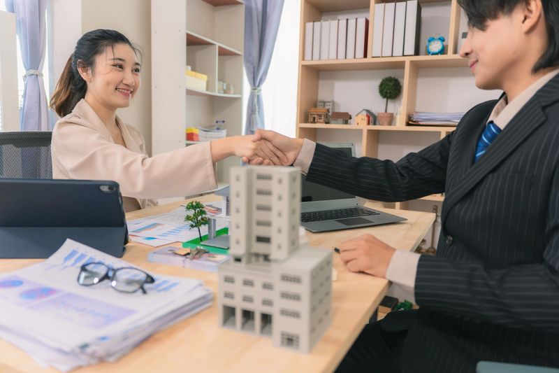 Business negotiations, real estate, real estate sales contracts, handshakes after the contract is completed, regarding home insurance and investment loans.