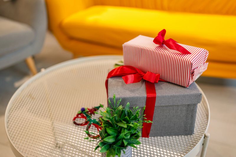 Two beautifully wrapped Christmas gifts sit on a stylish table in a cozy room. The warm atmosphere invites happiness and friendship during the holiday season filled with joy.