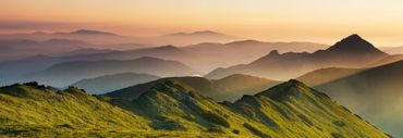 Green valleys under a bright blue sky