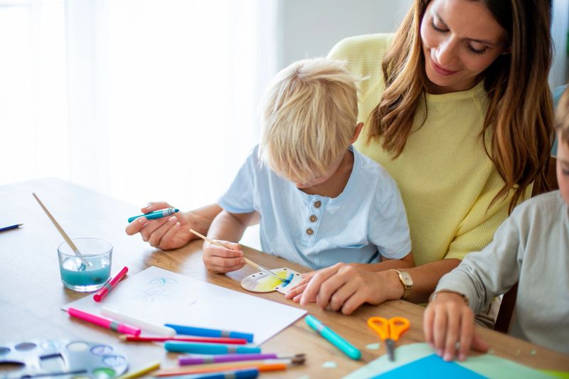 Mother and children enjoying creative arts and crafts activity together