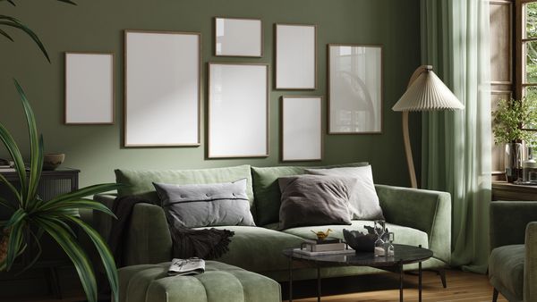 Cozy green living room with blank picture frames.