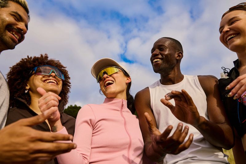 Young diverse friends enjoying an outdoor fitness session under a blue sky