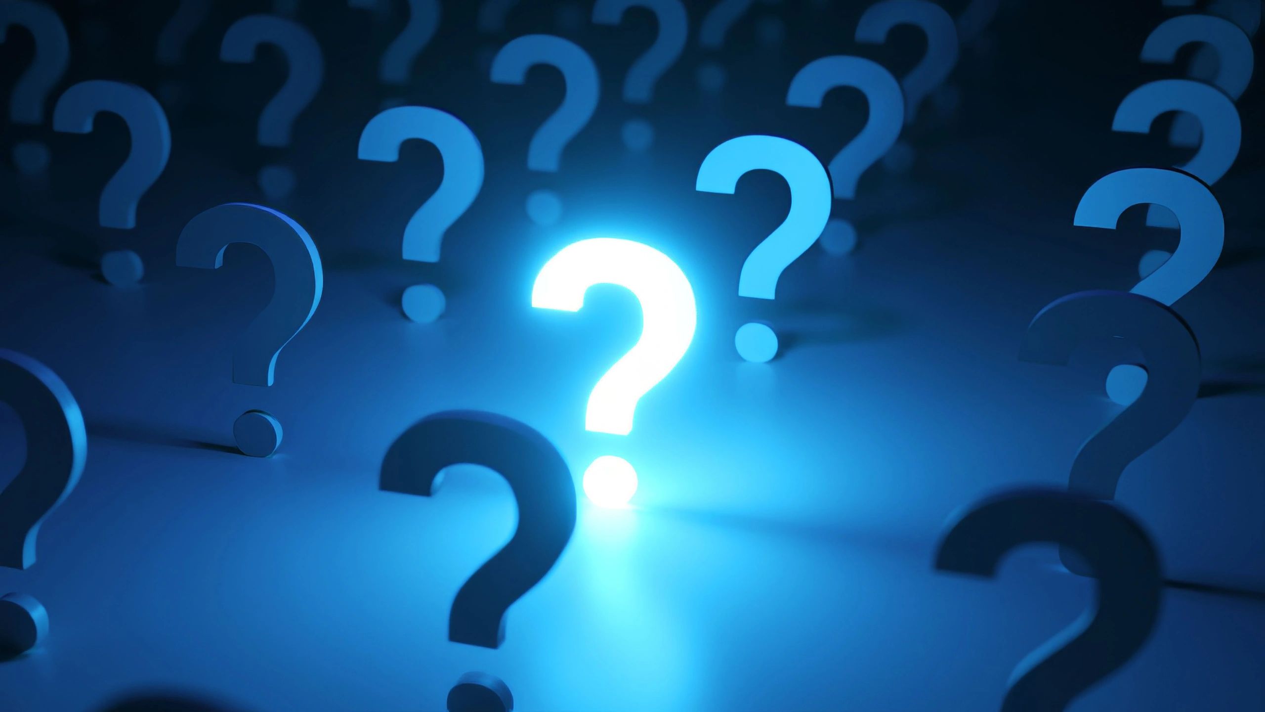 Glowing blue question marks scattered on a dark surface answering fire safety questions