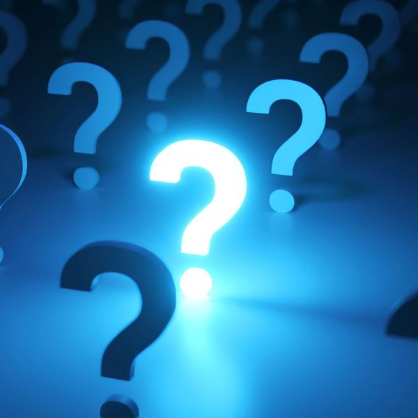 Glowing blue question marks on a dark surface.
