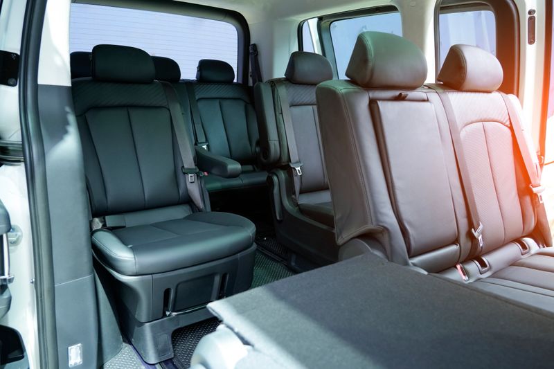 The interior of a modern vehicle showcases spacious seating with high-quality black material, perfect for comfortable urban commuting. The design features ample room and practicality.