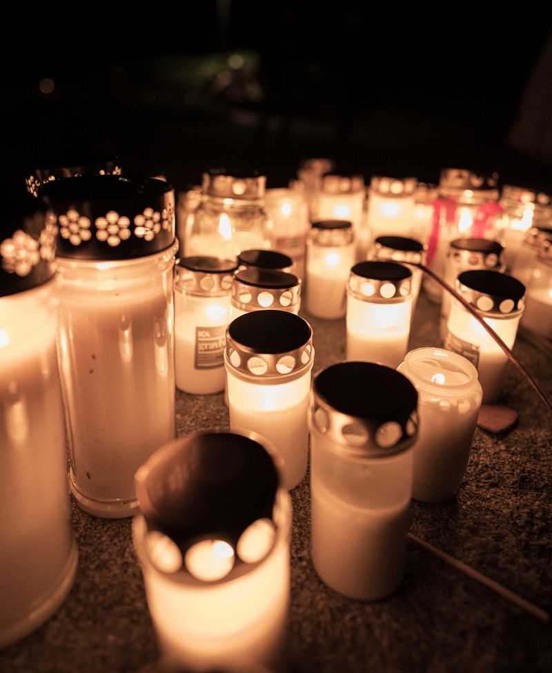 Collection of glowing memorial candles shining in darkness.