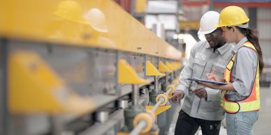 Two engineers inspecting machinery in a factory.