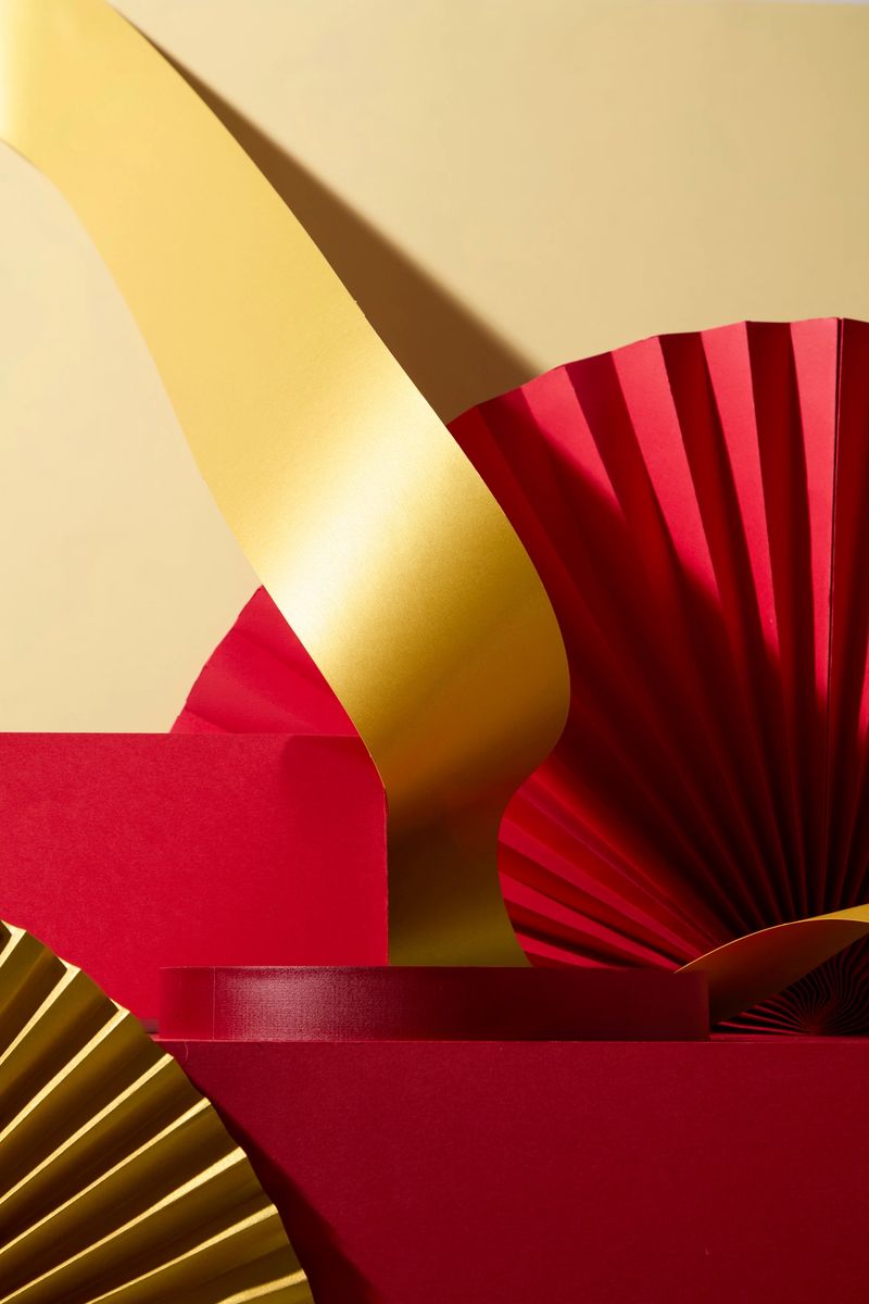 Vertical frame showing a gold ribbon element rising above red fans. Works well for poster designs requiring a strong celebratory focal point. Empty podium for design, lunar new year concept