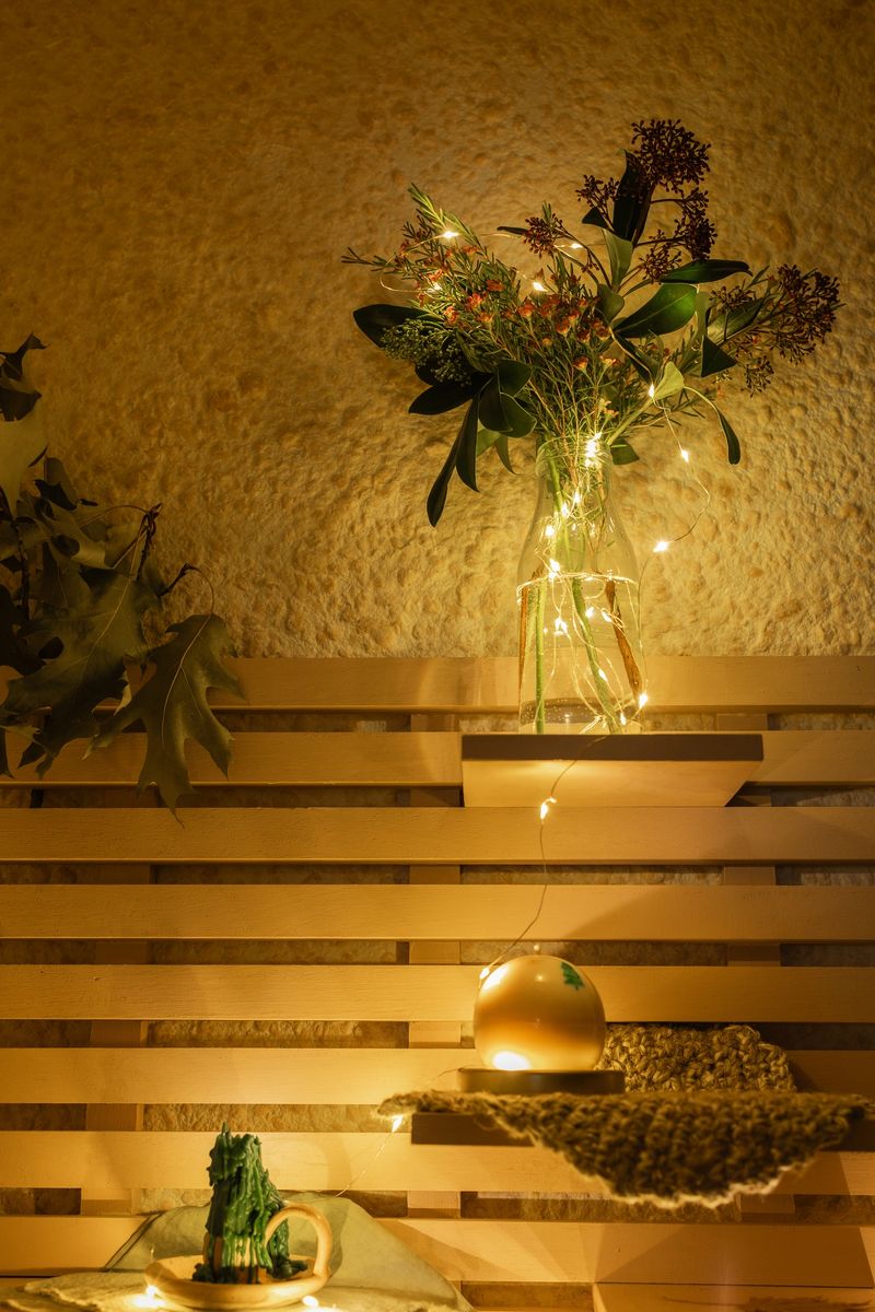 Bouquet with garland lights and candles on the shelf