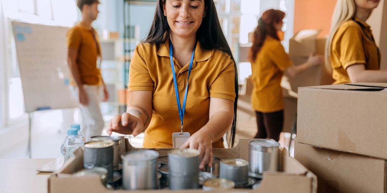 Volunteers sorting canned food in a donation center.