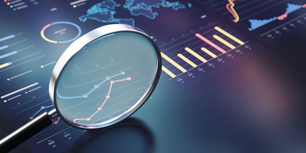 Magnifying glass focusing on rising trend lines on data charts.