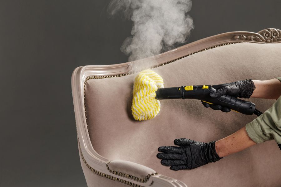 Nettoyage à la brosse vapeur du dossier d’un fauteuil capitonné