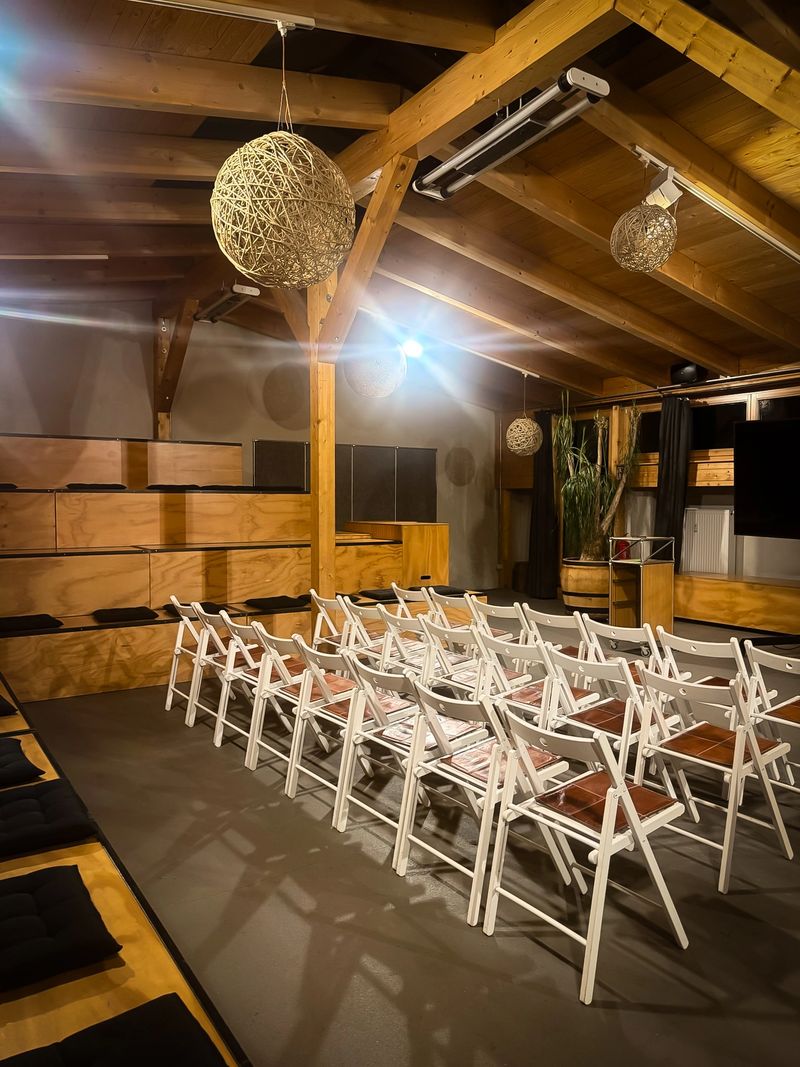 Preparing a room for a venue with white wooden chairs lined up for seating arrangements