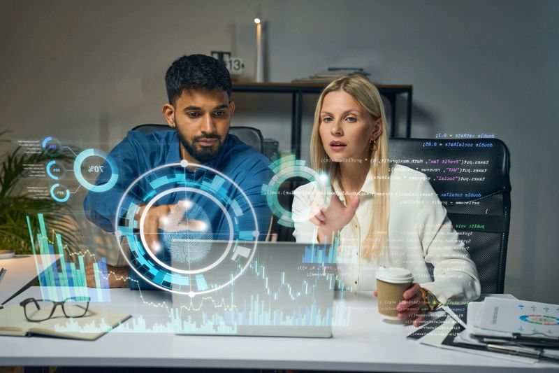 Two Professionals Collaborating On Futuristic Technology With Holographic Data, Symbolizing Innovation, High-Tech Solutions, Teamwork, And Digital Transformation In A Modern Office Setting.