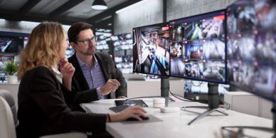 Professionals reviewing multiple security camera feeds.